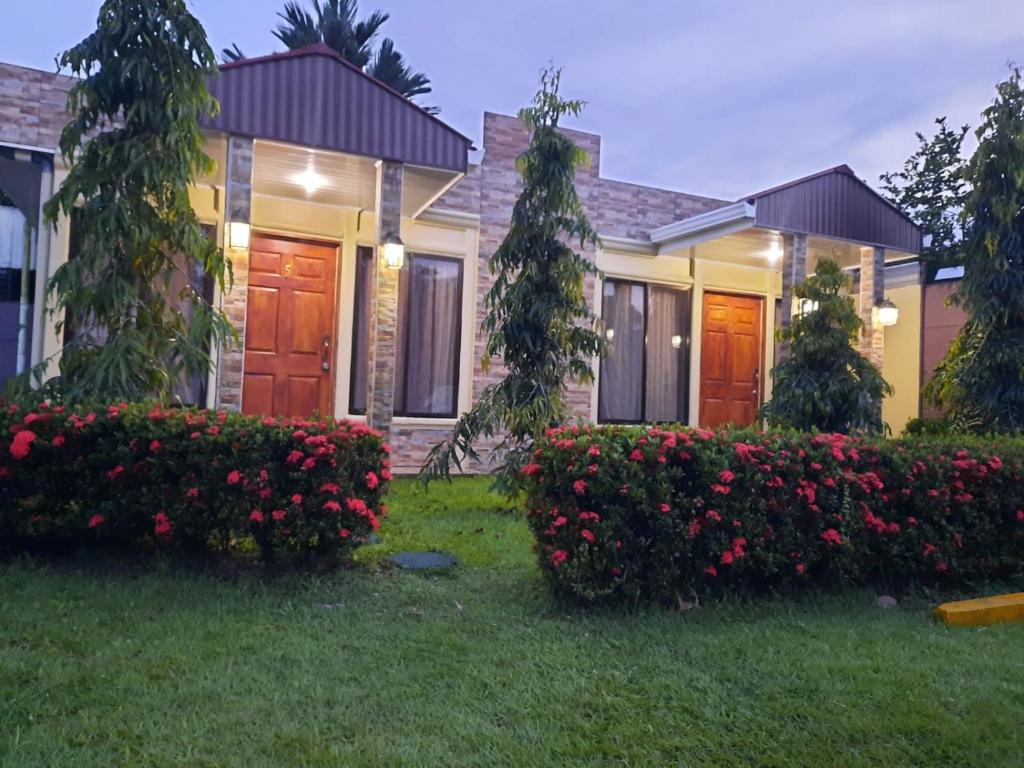 una casa con flores rojas en el patio en Hotel Boutique Malibu Los Sueños, en Tigre