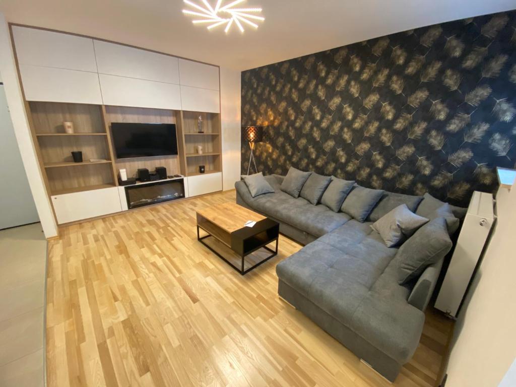 uma sala de estar com um sofá e uma televisão em Secret Apartments Chełmska 55m2 em Varsóvia
