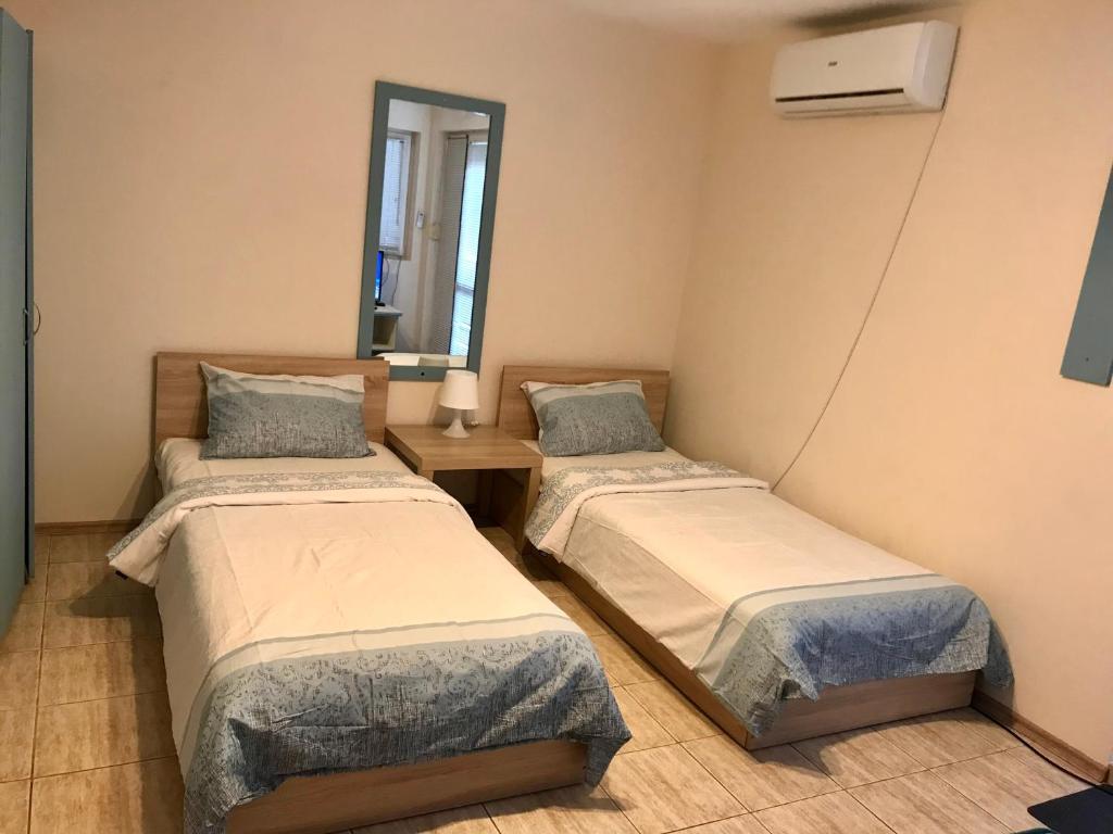 a room with two beds and a mirror at Ssenyange Guest House in Varna City