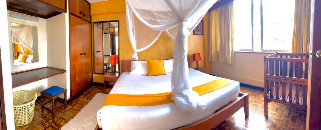 a bedroom with a bed with a canopy at Kenya Comfort Suites in Nairobi