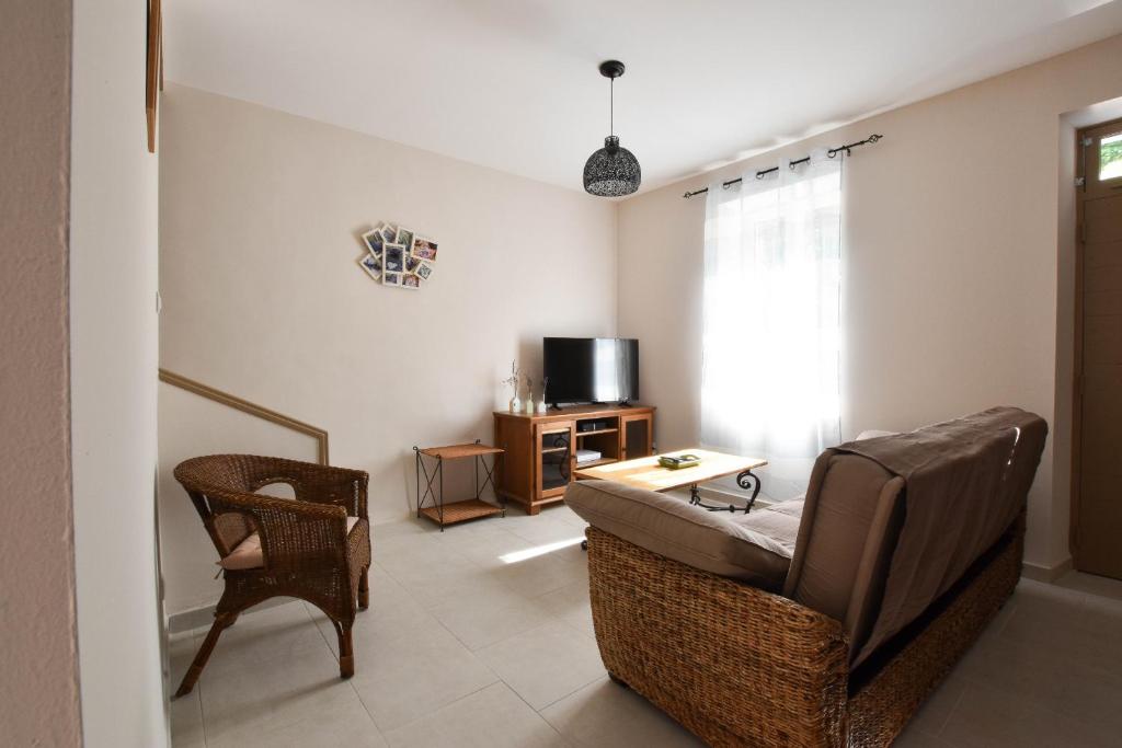 sala de estar con sofá, silla y TV en Felibrige - Clim - Cour, en Arles