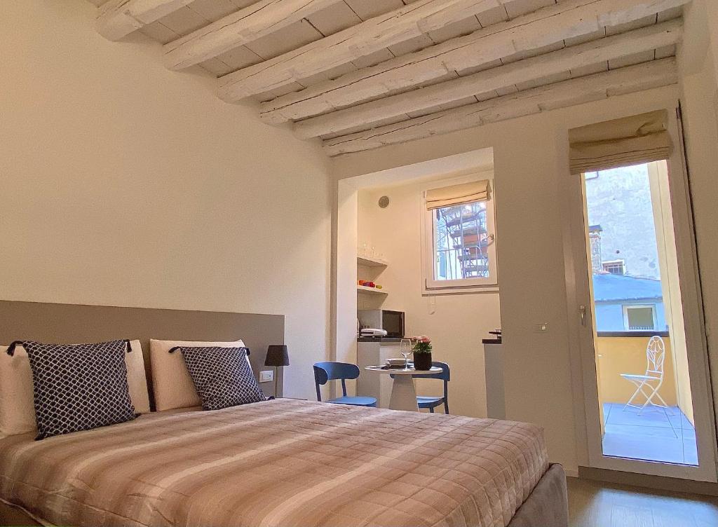 een slaapkamer met een groot bed en een balkon bij Residenza SubitoSanto - Appartamento 1B "Palladio" in Padua