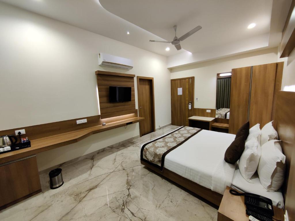 um quarto de hotel com uma cama e uma televisão em Hotel Lilichham em Udaipur