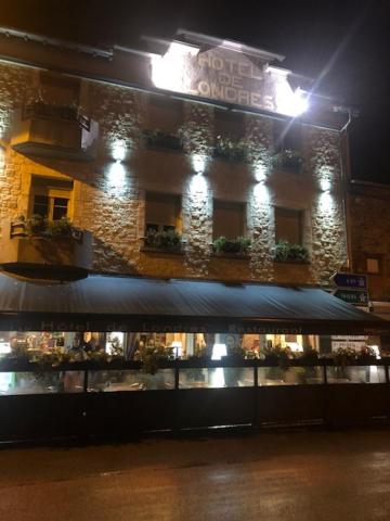 un negozio di fronte a un edificio di notte di Hôtel Restaurant de Londres a Saint-Just-en-Chevalet