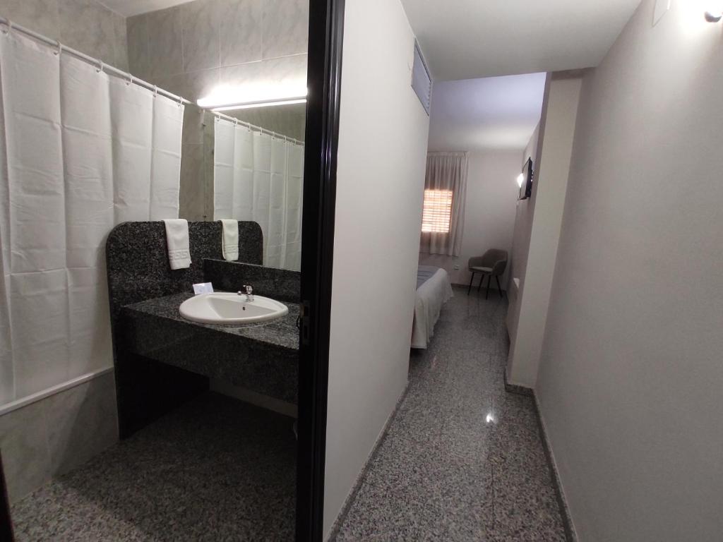 a bathroom with a mirror and a toilet at Hotel Querol in Valderrobres