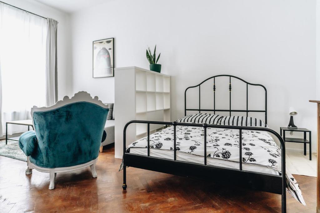 een slaapkamer met een bed en een stoel bij Podzamcze 24 Apartments in Krakau