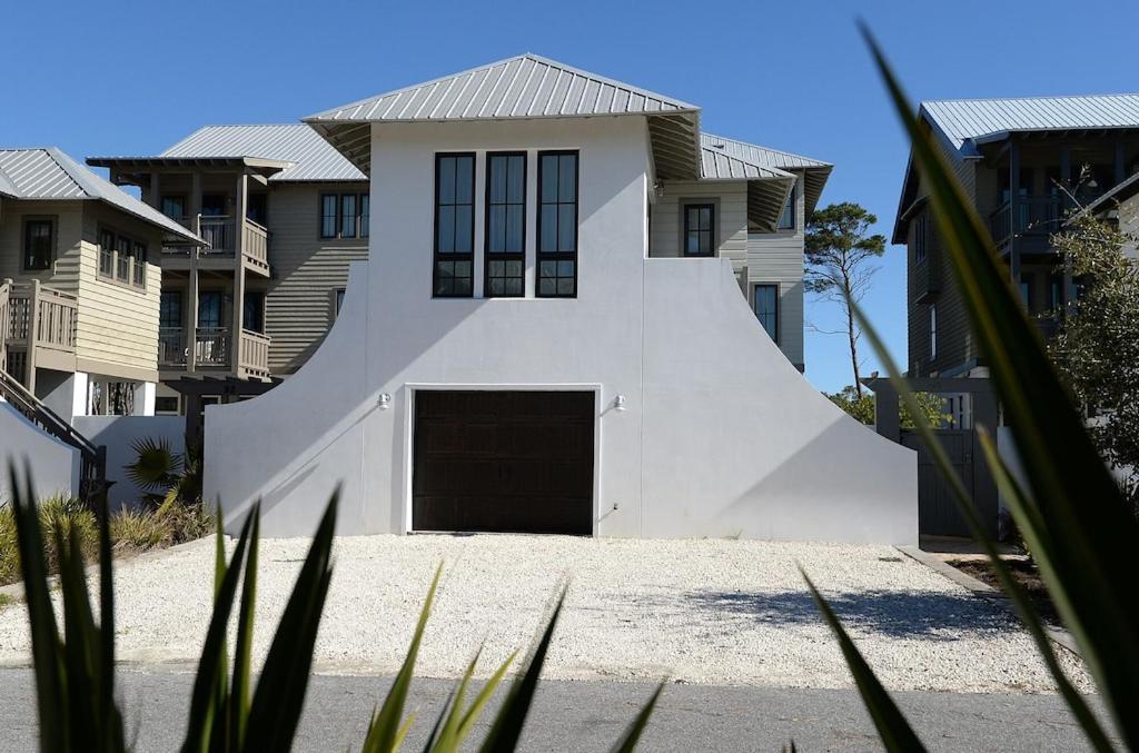 una casa blanca con garaje y algunas casas en Beautiful High End One Bed / 1 Bath Carriage House, en Rosemary Beach