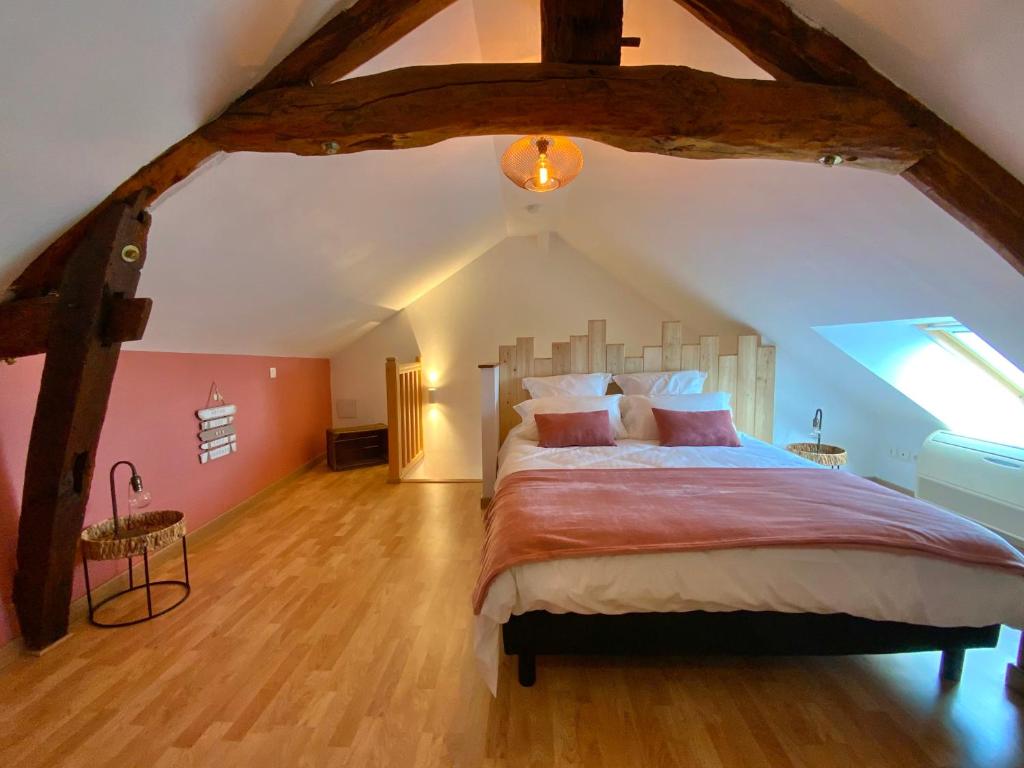 ein Schlafzimmer mit einem großen Bett im Dachgeschoss in der Unterkunft Gite LA VUE LOIRE Appartement in Saint-Denis-de lʼHôtel