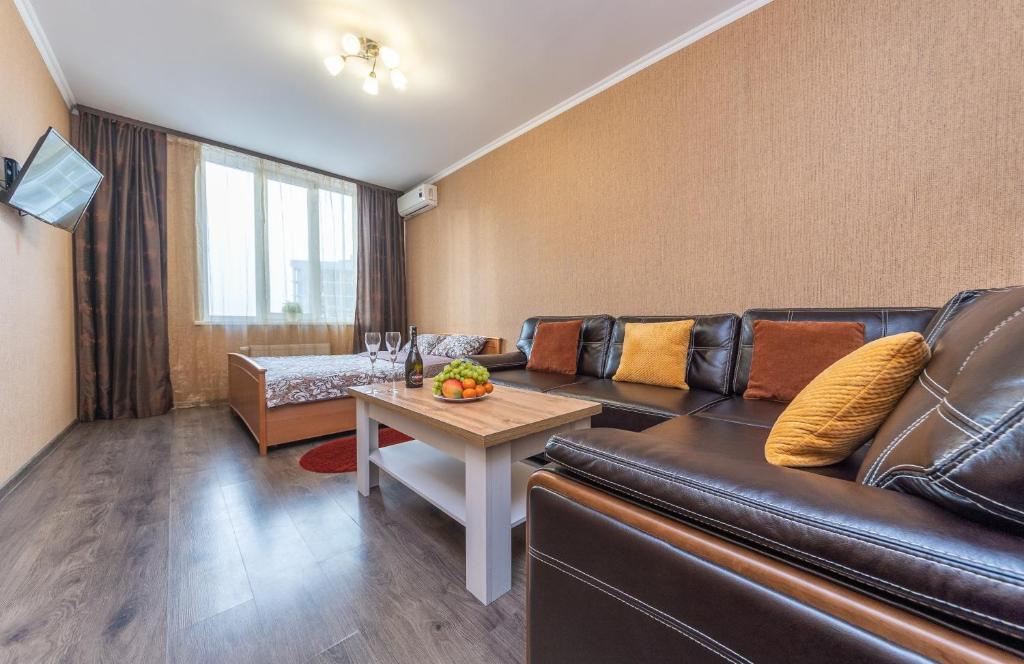 a living room with a leather couch and a table at Apartment with View on 24 floor in Kyiv