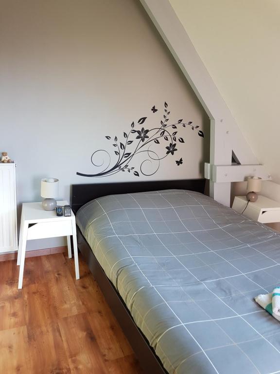 a bedroom with a bed and a staircase with a wall at Charmante chambre d'hôtes en Normandie in Valognes