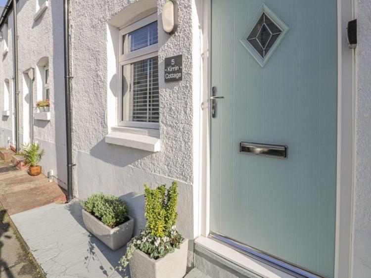 a front door of a house with potted plants at Kirrin Cottage in Conwy