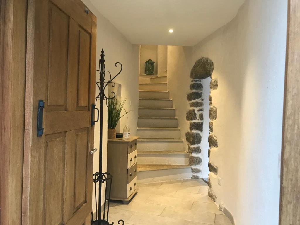 a hallway with a wooden door and a staircase at Casa Natalina de caractère entièrement rénovée classée 4 étoiles in Feliceto