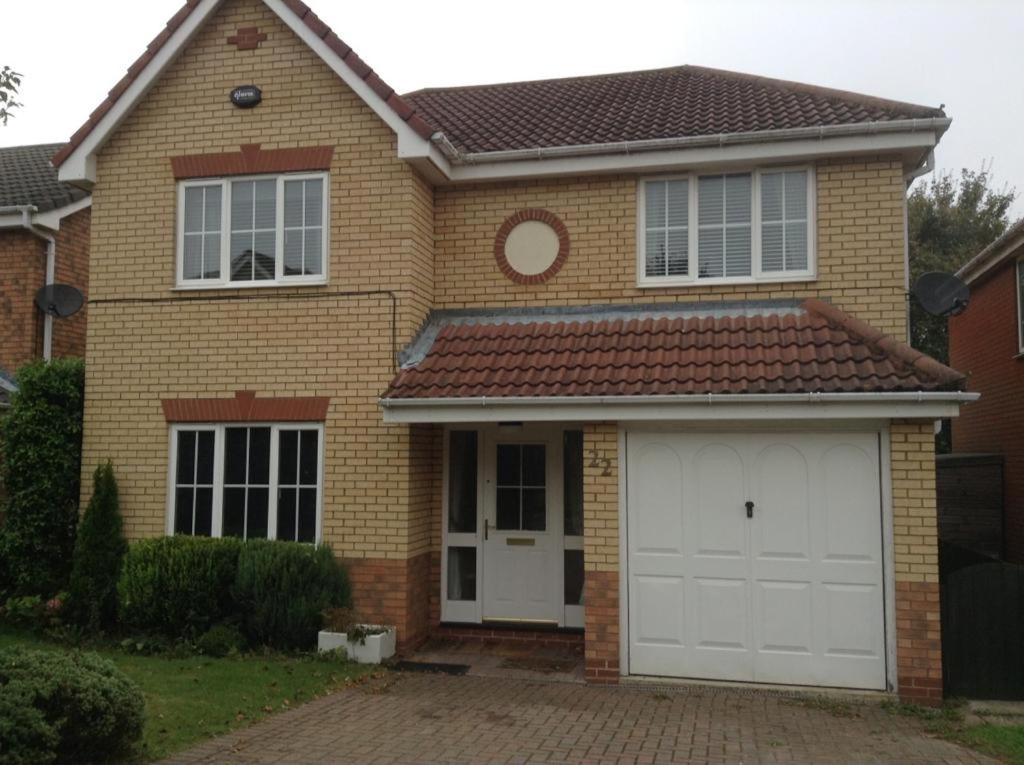 een stenen huis met twee witte garagedeuren bij Waller House in Norwich