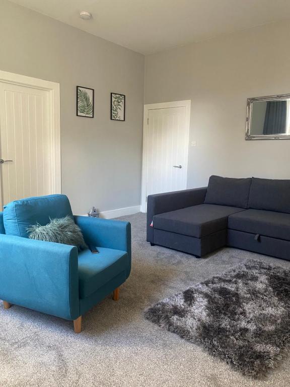 a living room with two couches and a blue couch at Town Centre Holiday Let in Hawick