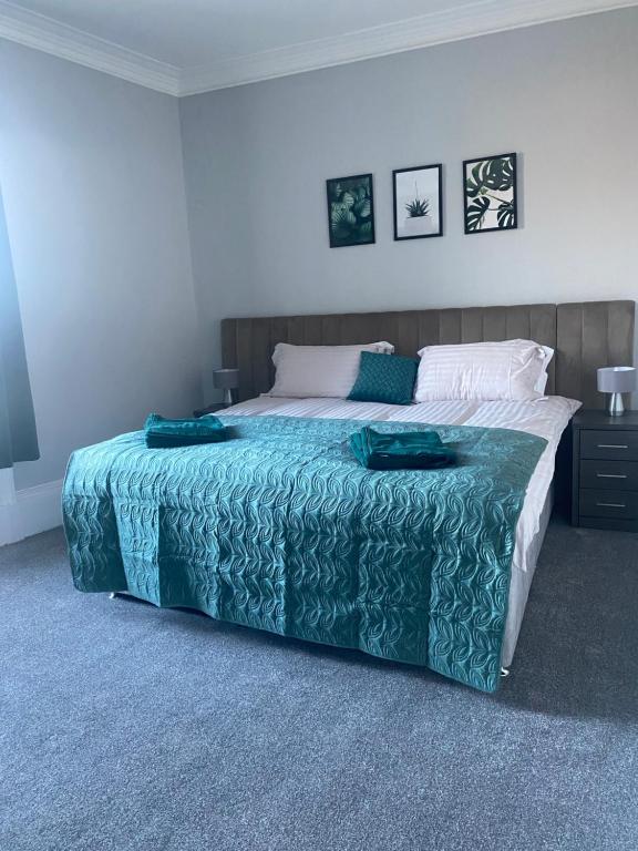 a bedroom with a large bed with a blue blanket at Town Centre Holiday Let in Hawick
