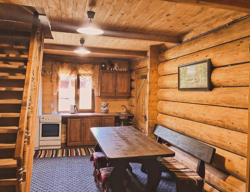 a kitchen with a wooden table in a cabin at Вершина Карпат in Krasnik