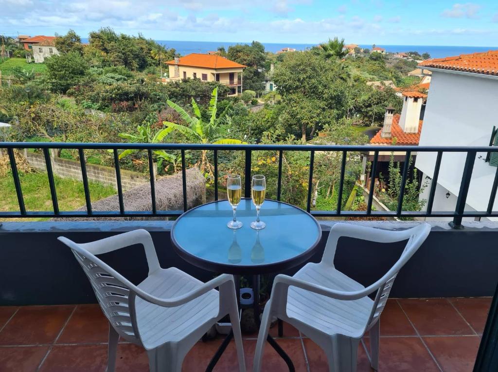 a balcony with a table and two glasses of wine at Scenic Comfort D in Ponta Delgada