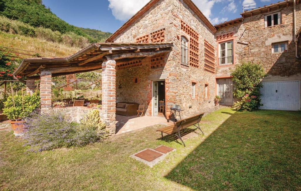 a stone house with a bench in the yard at La Celata in Lucca