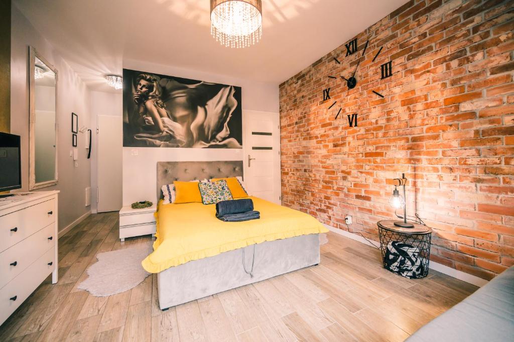a bedroom with a brick wall and a bed at Silver box in Gdańsk