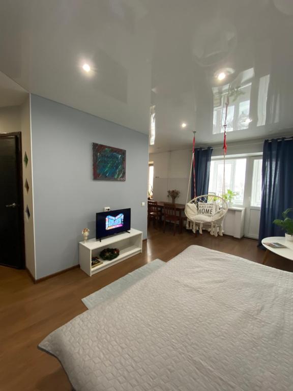 een grote woonkamer met een bed en een televisie bij ART apartment in Zhytomyr