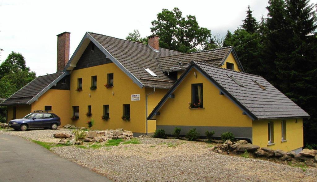 a yellow house with a black roof at Krokus in Piechowice