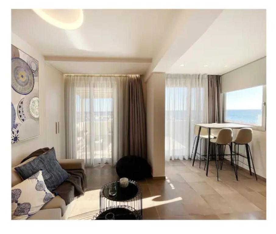 a living room with a couch and a table at Ioannas Endless Blue Apartment in Ierapetra