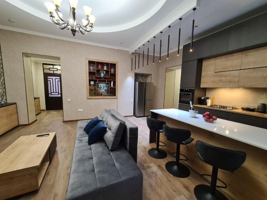een keuken en een woonkamer met een bank en een tafel bij Nino's Cosy Apartment in Koetaisi