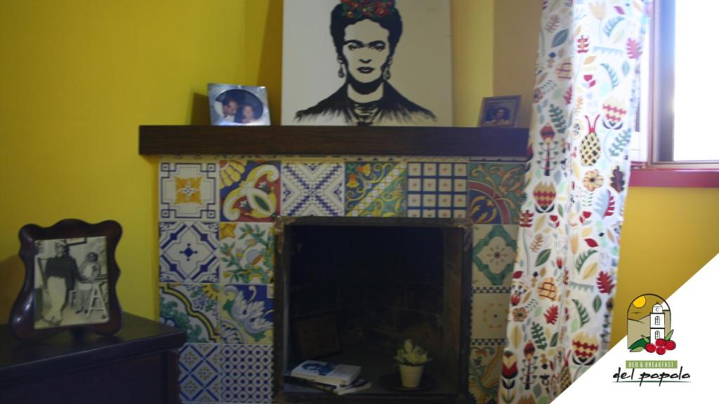 uma lareira com um retrato de um homem na parede em Bed & breakfast del Popolo em Savoia di Lucania
