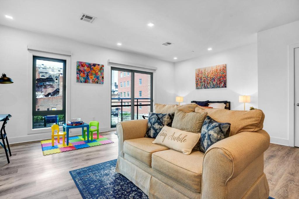 NEW! Vibrant Large Studio Dwntwn 18 Mins to NYC في نيوآرك: غرفة معيشة مع أريكة وطاولة