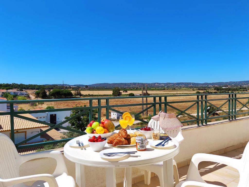 uma mesa com um prato de comida numa varanda em Falesia Beach Apartment by Be Cherish em Albufeira