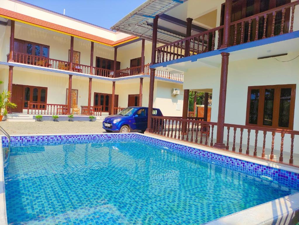 a swimming pool in front of a house at Kayaloram Resort in Pūvār