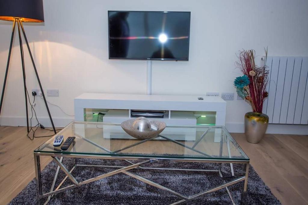 a living room with a glass table and a tv at UNIQUE 2 BED APARTMENT in London