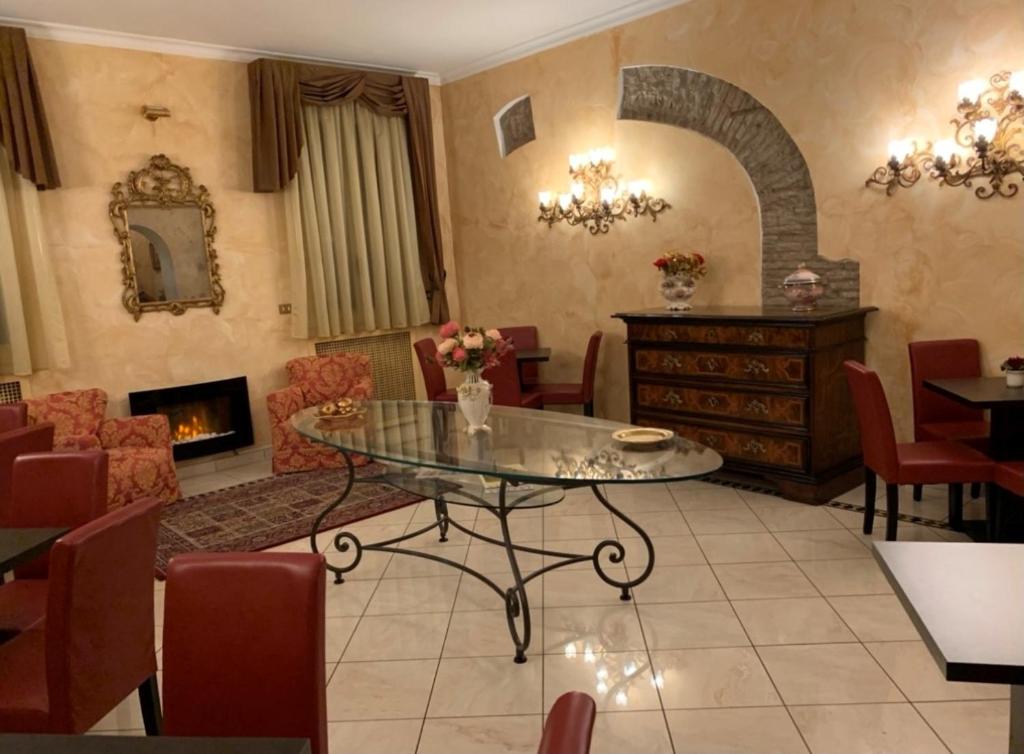 a living room with a table and chairs and a fireplace at Hotel Roma in Bologna