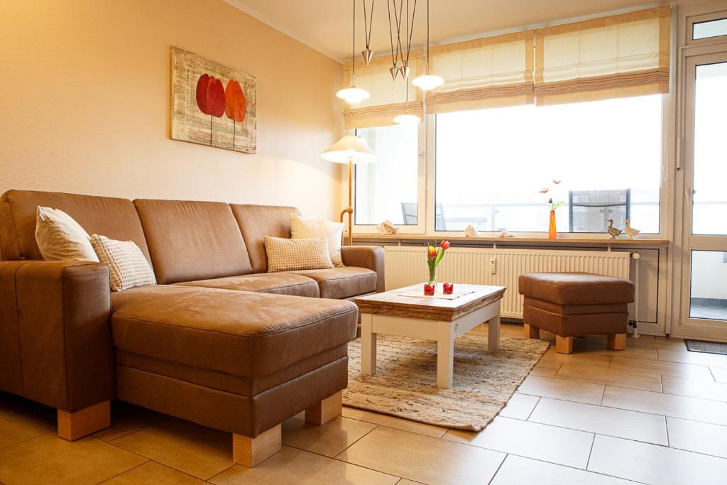 ein Wohnzimmer mit einem Sofa und einem Tisch in der Unterkunft Haus Uthlande Uthlande Whg 4 in Wyk auf Föhr