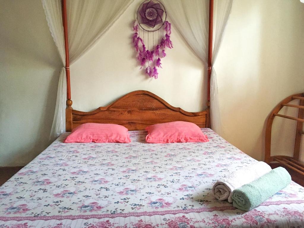 a bedroom with a bed with two pink pillows at location weligama in Weligama