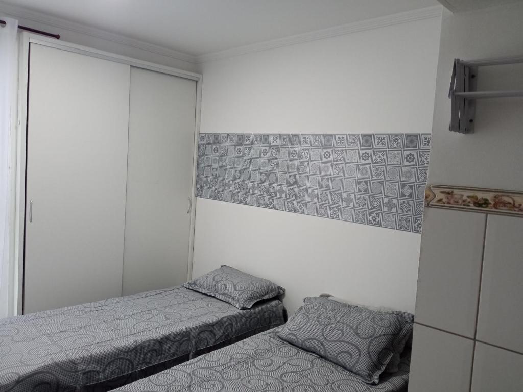 a small bedroom with two beds and a refrigerator at kit Catavento in Brasilia