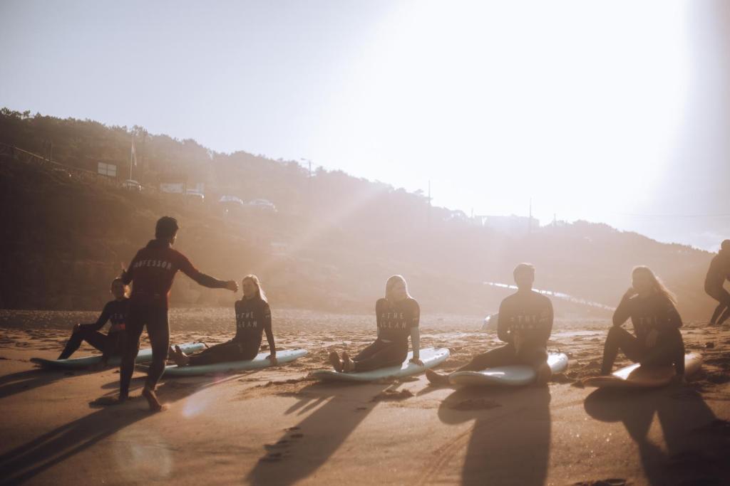 a group of people sitting on the beach with surfboards at João Jungle in Açafora