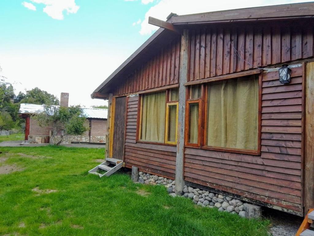 una pequeña casa de madera con una ventana en un patio en Don Edmundo Trevelin en Trevelín