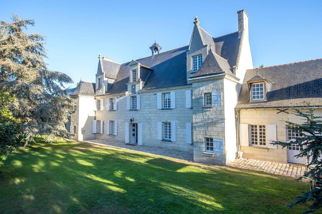 una gran casa blanca con un gran patio en Château de la Ronde en Vivy