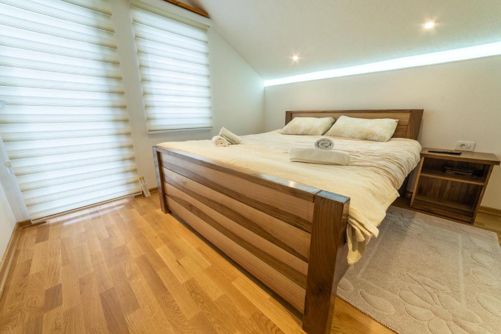 a bedroom with a large bed with a wooden headboard at Seosko domaćinstvo Kastratović in Berane