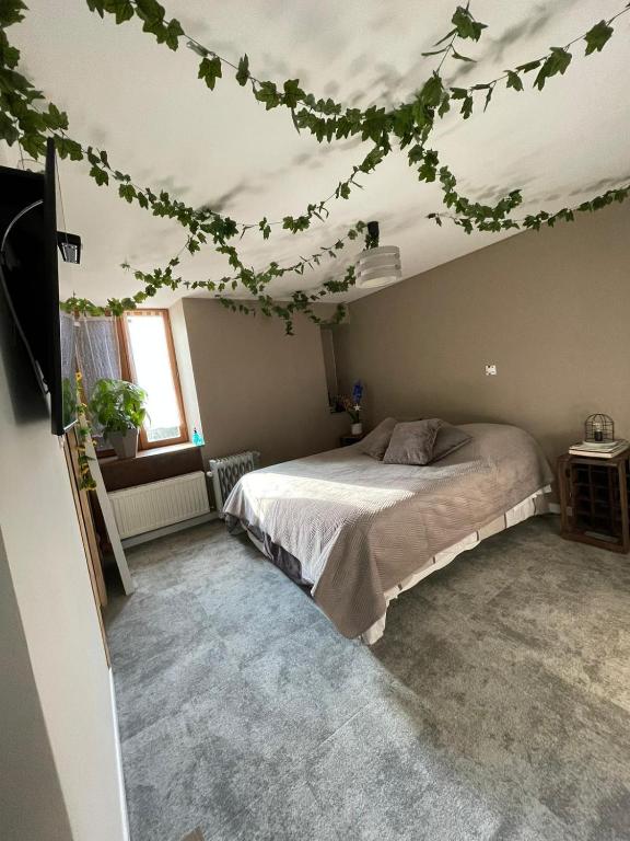 a bedroom with a bed with ivy on the ceiling at "Les Chaillottes" in Chailles