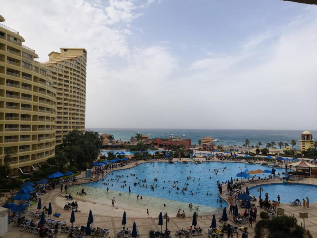 a group of people in a swimming pool at a resort at شقق اهرامات بورتو السخنه in Az Za‘farānah