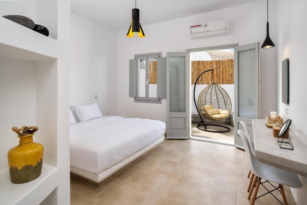 Schlafzimmer mit einem Bett, einem Schreibtisch und einem Tisch in der Unterkunft Astivi Santorini Apartments in Pirgos