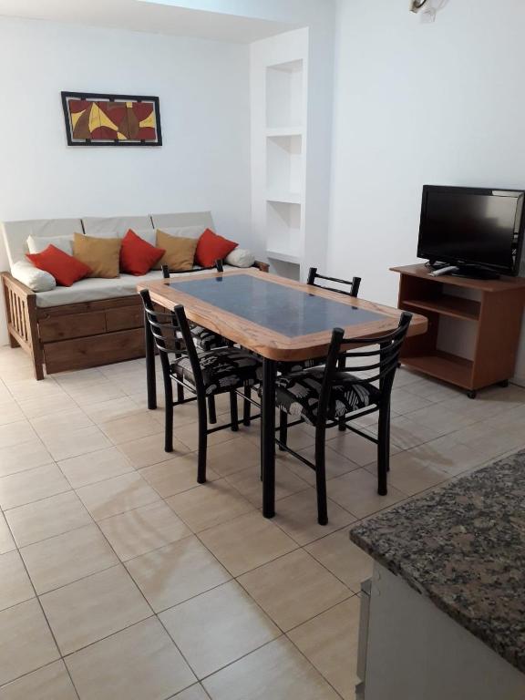 einen Tisch und Stühle im Wohnzimmer mit Sofa in der Unterkunft Departamento Anita centro in Maipú
