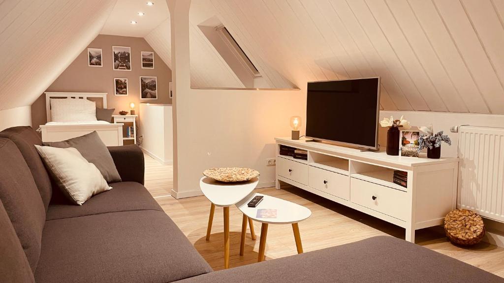 ein Wohnzimmer mit einem Sofa und einem Flachbild-TV in der Unterkunft AR Apartments II I 5 Pers I Prime I Küche I WLAN I am Thüringer Meer in Unterwellenborn