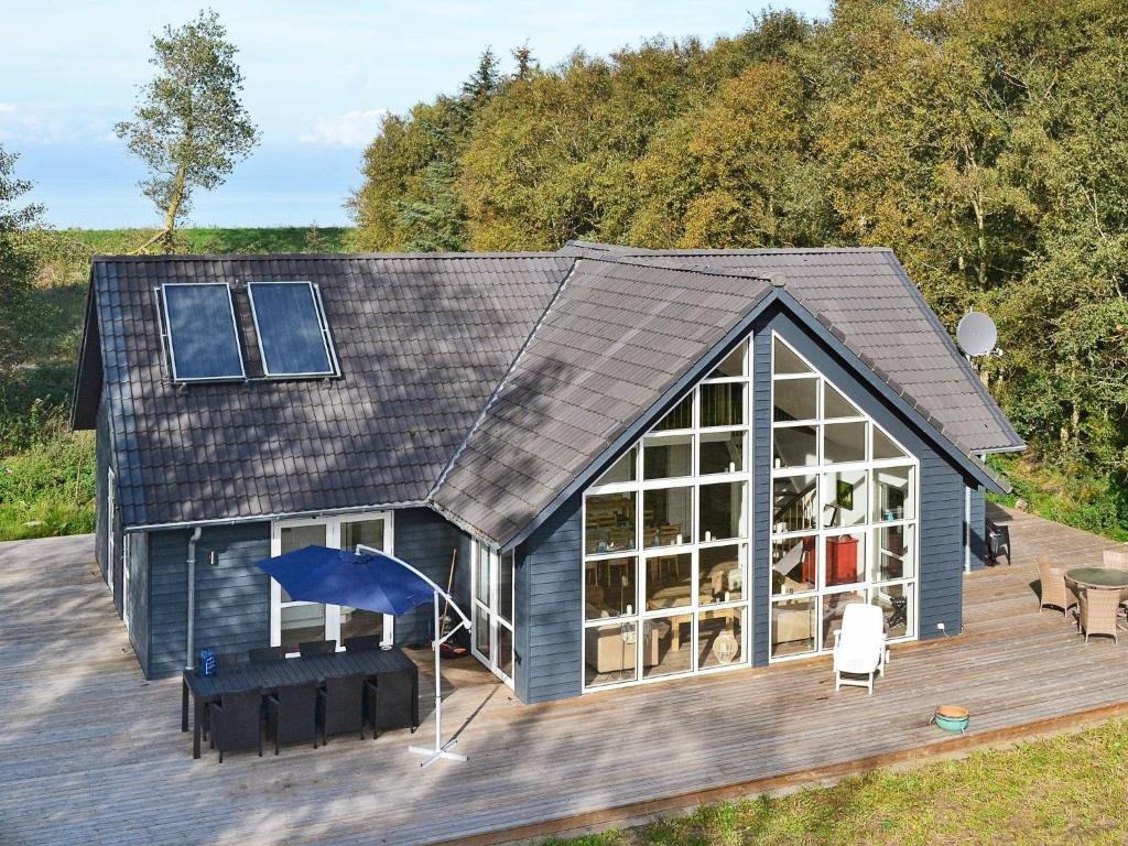 ボーゲンセにある8 person holiday home in Bogenseの屋根とデッキのある小さな家