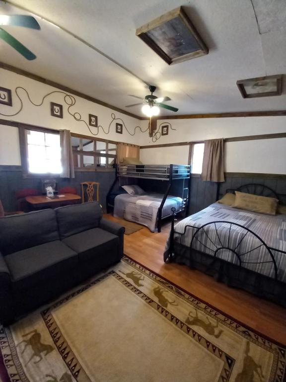 een woonkamer met 2 bedden en een bank bij Acorn Hideaways Canton Old West Bunkhouse for 9 - Trail's End Corral in Canton