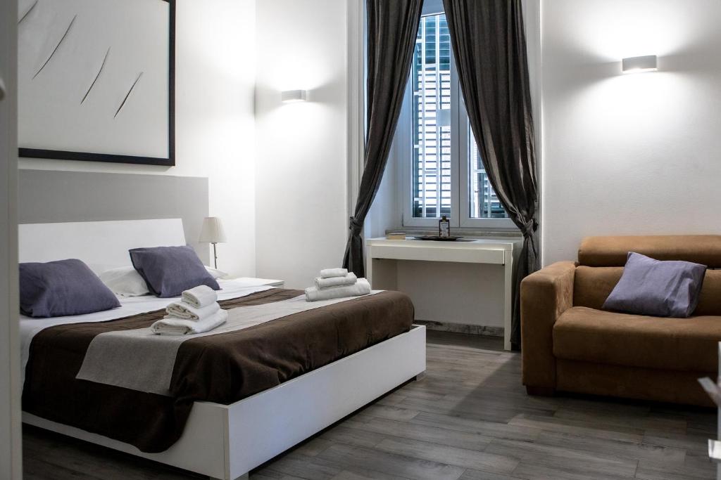 パレルモにあるPalermo al Centro - Appartamento Fiumeのベッドと椅子付きのホテルルーム
