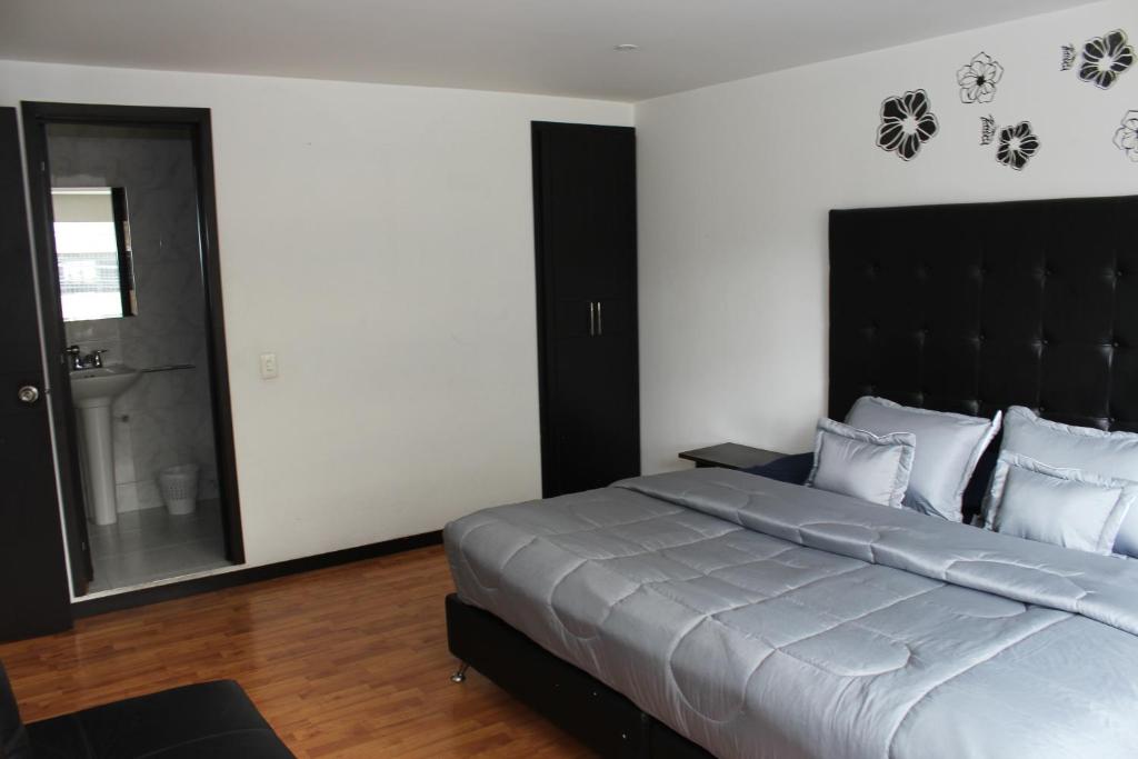 a bedroom with a large bed with a black headboard at Hotel Dorado Plaza Bogota in Bogotá