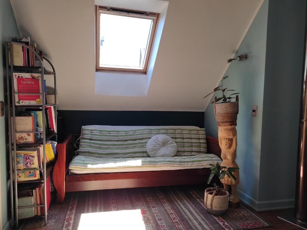 a small bed in a room with a window at Hospedaje Austral in Puerto Montt